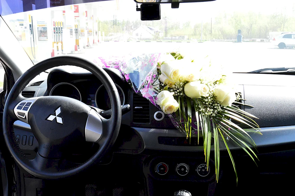 Strauß weißer Rosen im Auto
