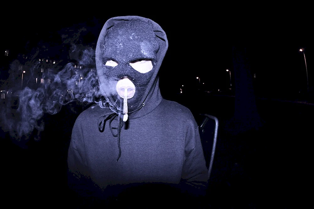 Der Typ in einer Maske mit einer Zigarette