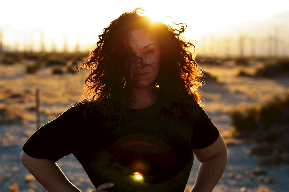 Mädchen mit gewelltem Haar bei Sonnenuntergang