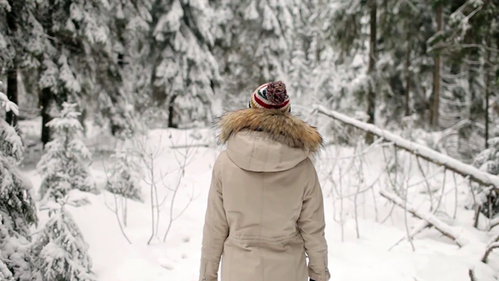 Mädchen im Winterwald mit Rücken
