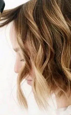 Gebrochene Locken auf einem Bob mit einem Glätteisen