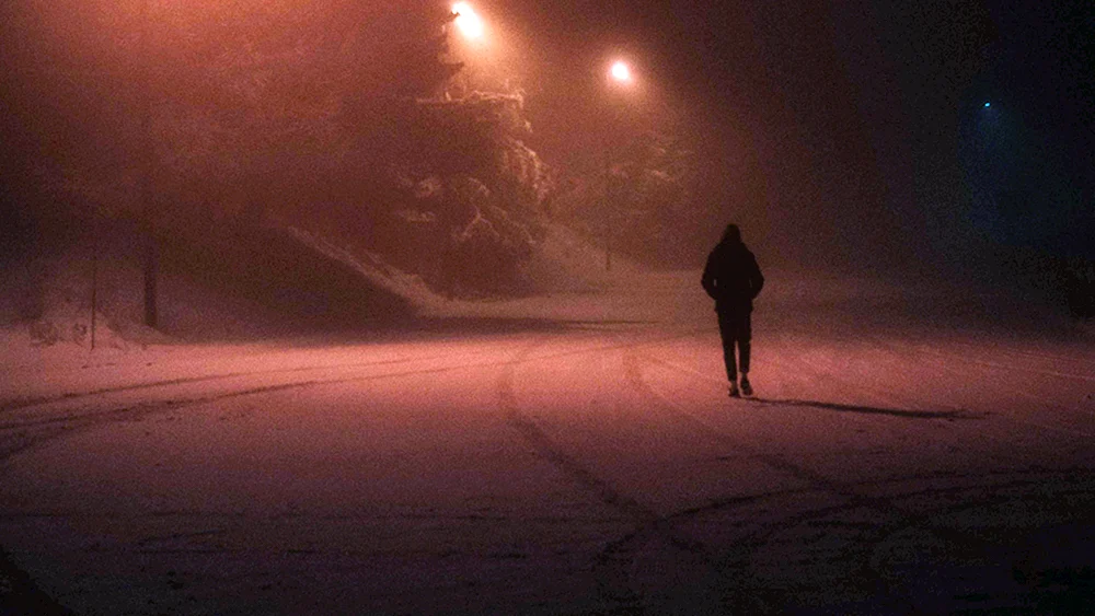 Ein einsamer Kerl auf dem Dach bei Nacht