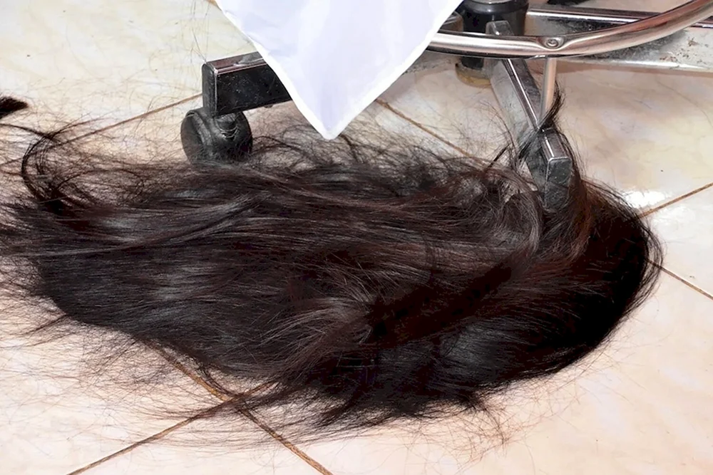 Schwarzes Haar auf dem Boden abschneiden