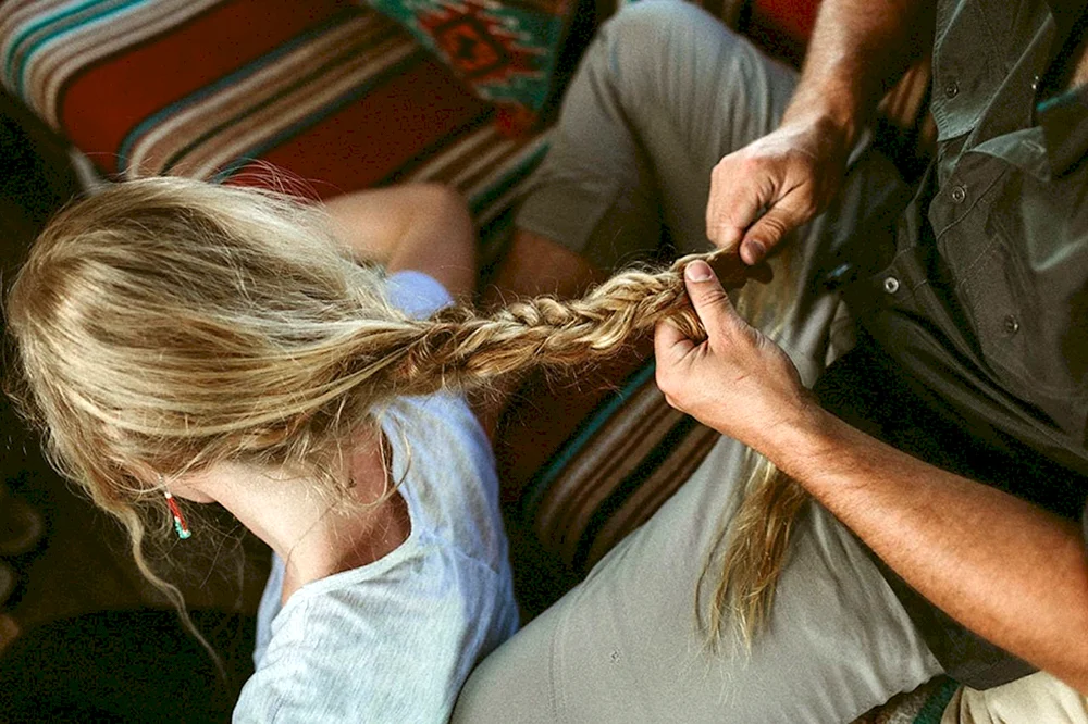 Eine Frau, die einem Mädchen die Haare in den Händen hält