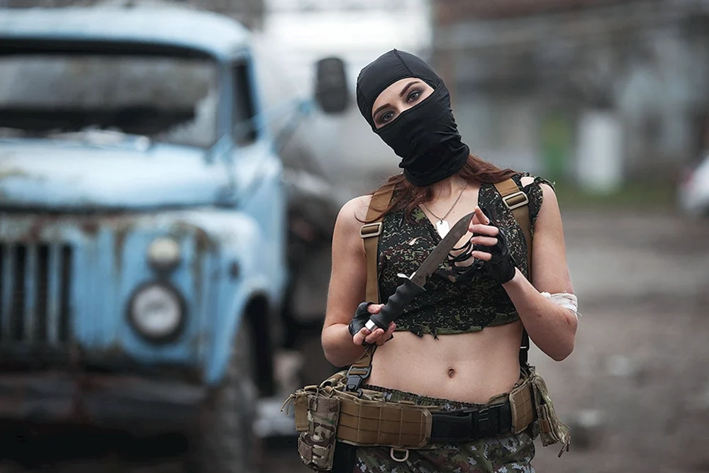 Mädchen in Balaclava mit einem Gewehr