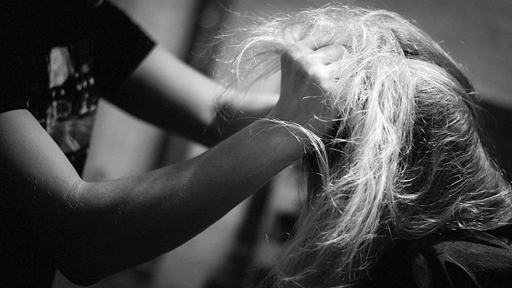 Ein Mann, der einem Mädchen die Haare in den Händen hält