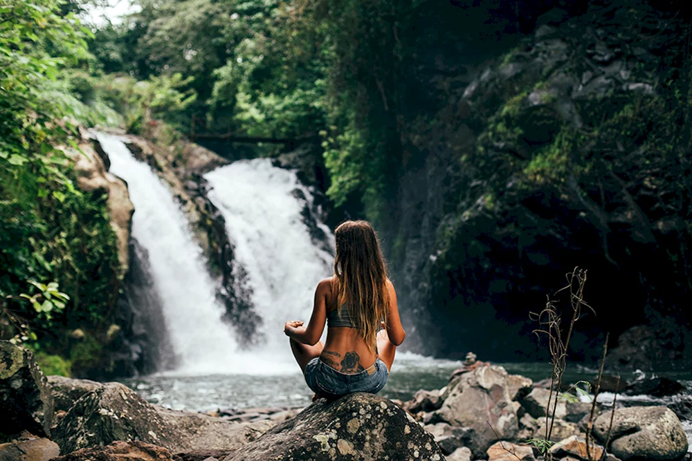 Frau unter dem Wasserfall